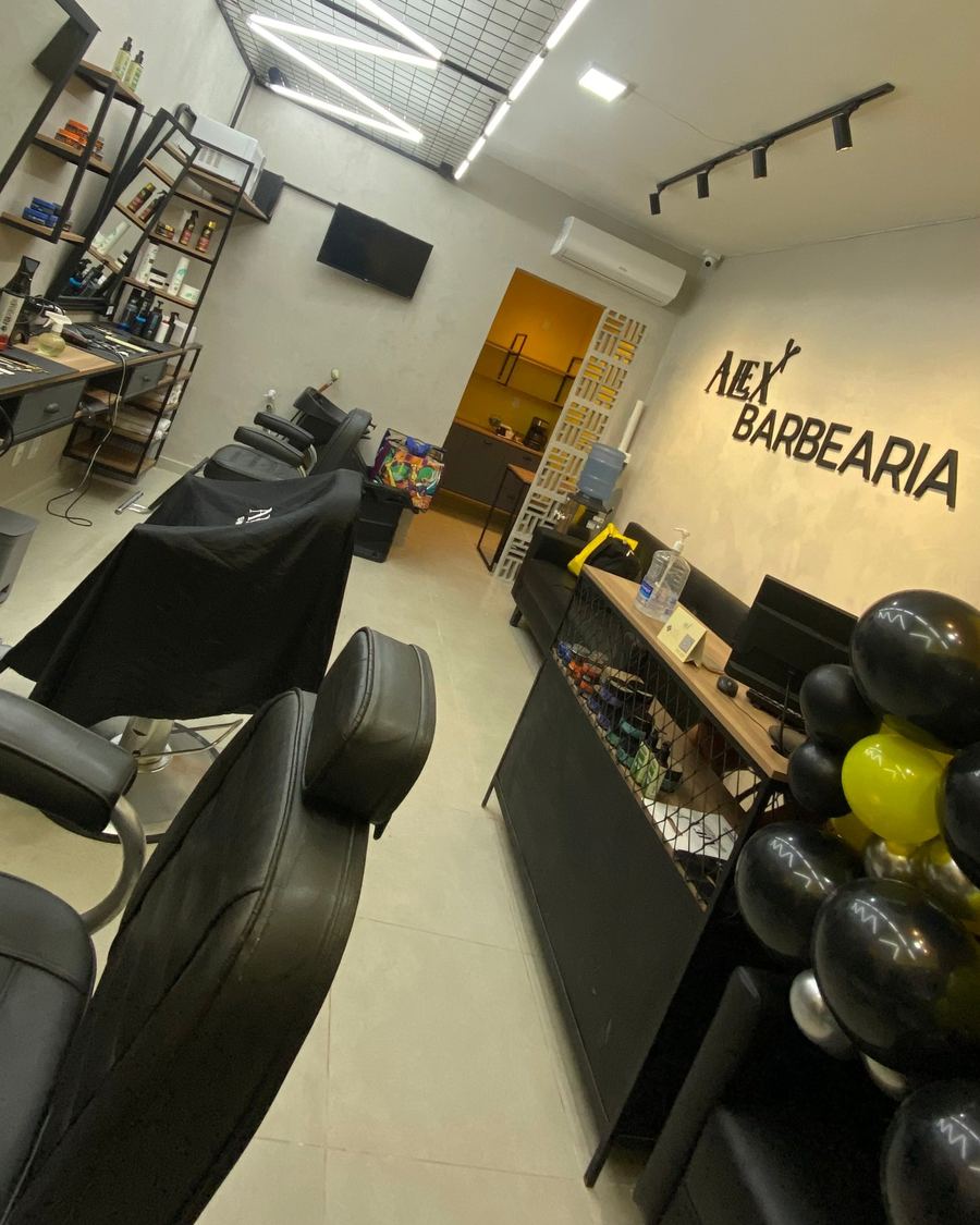 Interior da Alex Barbearia com as cadeiras e o letreiro