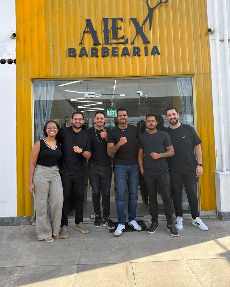 Equipe da Alex Barbearia em frente à fachada amarela