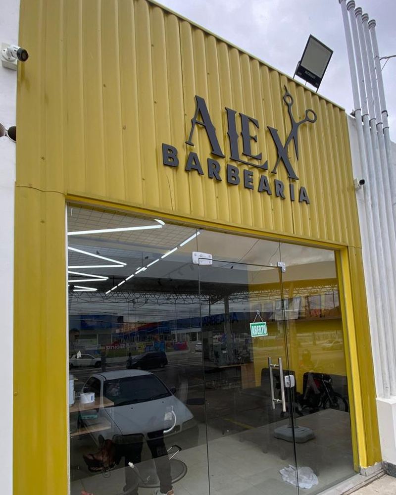 Fachada amarela da Alex Barbearia com o letreiro